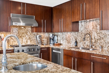 Honua Kai Hokulani 825 features a sleek kitchen with custom cabinetry and stainless steel appliances.