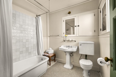 Bright full bathroom with soaking tub and classic tile.