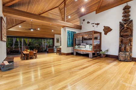 Step into this stunning open-concept living space where gleaming hardwood floors meet soaring wood-beamed ceilings, creating your perfect tropical retreat.