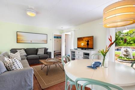 Relax in Lanikai Cottage's main house living room, complete with comfortable seating and direct access to the pool.