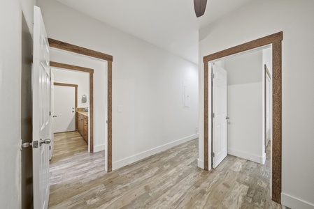 Wide hallway and entry space with wood-style flooring and crisp white walls for a modern island vibe.