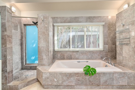 Indulge in your private marble sanctuary with deep soaking tub, separate shower, and serene city views for ultimate relaxation.