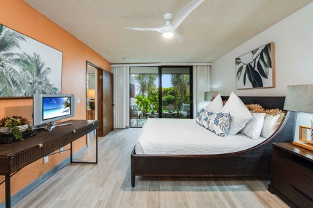 Retreat to the serene primary suite featuring a California king bed, ensuite bath, and private lanai access for ultimate relaxation.