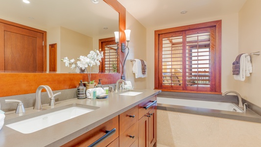 The primary guest bathroom has a double vanity and luxurious soaking tub.