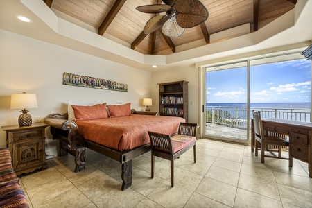 Guest bedroom equipped with a king-sized bed, private lanai access, and peaceful tropical views.