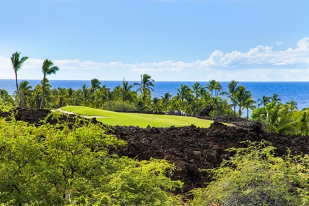 Unwind with a fairway view framed by lava rock and palm-dotted coastline.