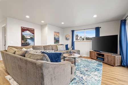 Sink into plush sectional seating while you enjoy movie nights on the large TV in this bright, welcoming living room.