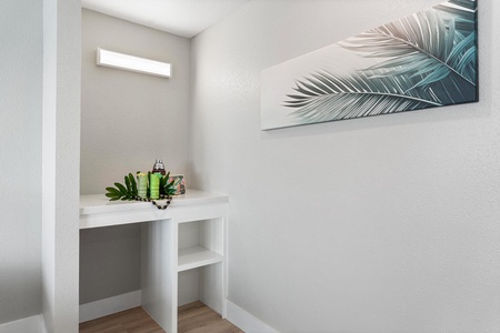 Bright vanity nook for getting ready, accented with a modern tropical art piece.