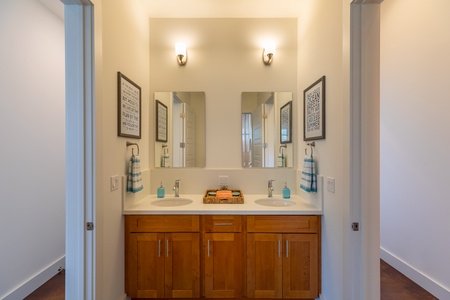 Convenient shared bathroom with dual sinks and modern finishes, perfect for families or groups staying together.