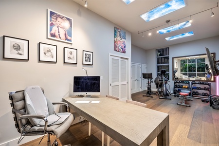 Versatile room with desk, workout gear, and lounge seating—stay productive or break a sweat.