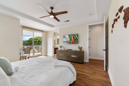 The primary bedroom also features a TV, fan, and access to a lanai.