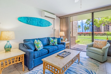 The cozy living area offers comfortable seating with direct access to the lanai, perfect for relaxing while enjoying views of the garden and ocean.