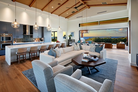 Spacious and elegant living room with vaulted ceilings, natural light, and seamless indoor-outdoor flow.