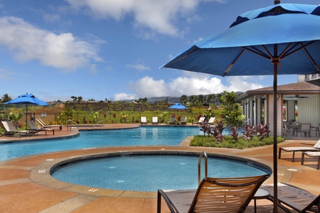Resort-style pool area with circular hot tub and mountain views, perfect for relaxing under tropical skies.