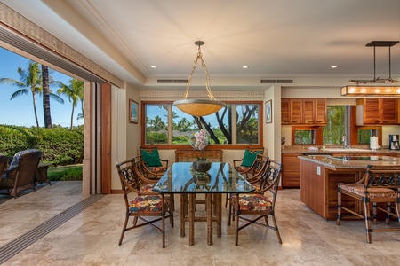 The dining area features a glass table for four and direct access to the lanai.