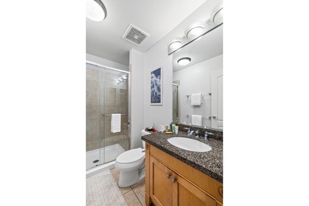 Hall bath provides a roomy vanity and glass-enclosed walk-in shower for easy rinse-offs.
