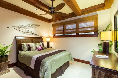 Guest cottage bedroom with warm wood finishes and tropical charm.