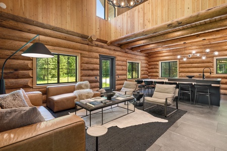 Modern meets rustic in this cabin's kitchen, featuring a spacious island dining table/bar seating surrounded by natural wood—a perfect blend for entertaining.