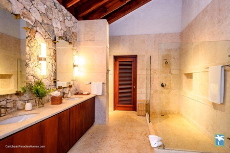 Elegant ensuite bathroom with a glass-enclosed shower and stone accents.