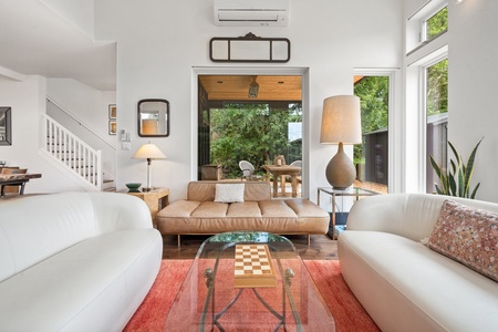 Open and bright, this living room blends style and comfort with plush seating and serene garden views.