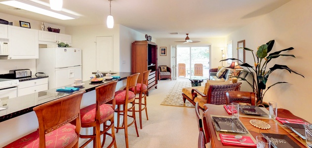 A welcoming home designed for family time, featuring an open floorplan that connects dining, kitchen, and living areas, all leading to the lanai.