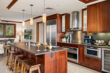 A Roy Yamaguci designed kitchen with stainless steel appliances and a cozy living room area.