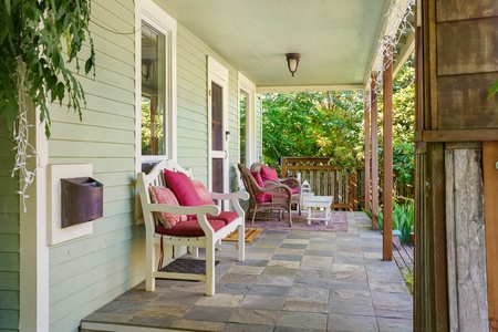 Settle into your private covered porch with plush cushioned seating, where morning coffee tastes better surrounded by lush garden views.