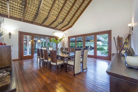 Elegant dining area with wooden floors and garden views.