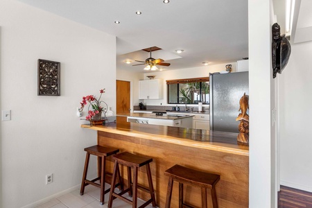 The kitchen island/bar has seating for three, perfect for quick meals or entertainment.