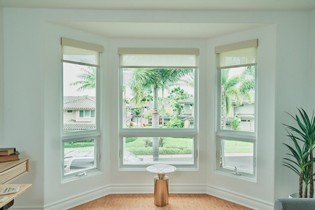 Natural light floods through your bay windows, offering peaceful neighborhood views and tropical palm scenery.