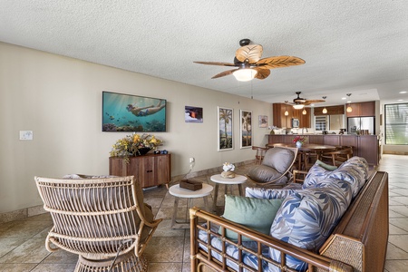Rattan chairs, a soft sofa, and the water doing the entertaining beyond the glass.