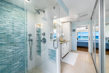 Glass-enclosed shower with dual heads and beachy accents—rejuvenate after a swim or rinse off the day’s adventures.