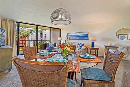 This beautifully set dining area with wicker chairs invites you to enjoy meals together while taking in the ropical views just outside the large windows