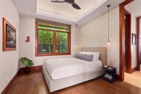 Guest bedroom with queen bed and garden view.