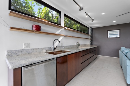 A sleek modern kitchenette with ample counter space and lush tropical views.