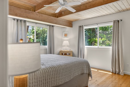 Relax in the spacious guest room with Cal king bed, breezy windows and vaulted wood ceilings.
