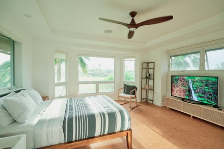 Relax in your bright, airy bedroom with tropical views and modern comforts, including a ceiling fan and large TV for your entertainment.