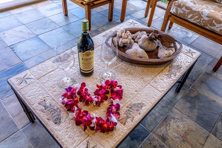 Romance awaits with wine, tropical flowers, and seashells artfully arranged for your perfect getaway moment.