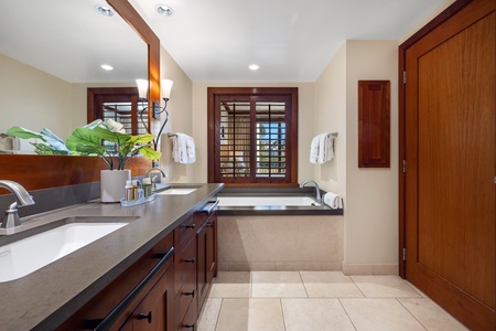 Unwind in your luxurious bathroom featuring rich wood finishes, dual vanities, and a deep soaking tub perfect for relaxing after island adventures.