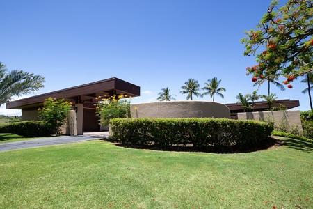 Manicured gardens frame the villa with lush greenery and tropical beauty.