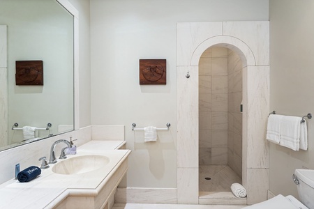 Your elegant marble bathroom features a spacious walk-in shower and luxurious soaking tub for ultimate relaxation.