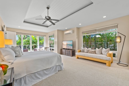 Relax in your spacious bedroom with a cozy seating area, tropical garden views, and modern amenities for the perfect retreat.