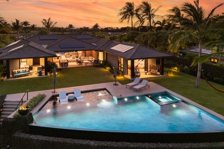 Luxurious infinity pool with swaying palms and mountain views creating the perfect Hawaiian paradise backdrop.