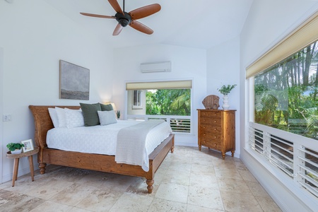 King bedroom suite with cozy furnishings, natural light, and calming tropical views.