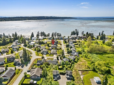 Coastal neighborhood nestled between lush forest and expansive tidal flats, offering serene beachfront access and scenic natural surroundings near the property area.