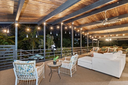 Unwind under twinkling string lights on your private covered terrace, where plush seating and tropical views create the perfect evening retreat.