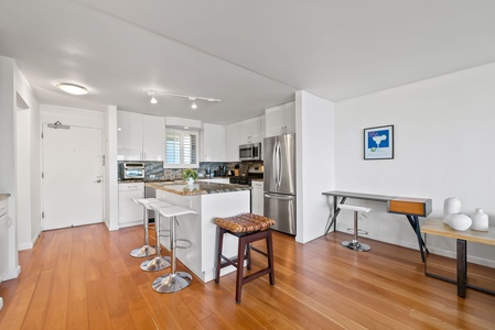 Light-filled and functional, the kitchen area includes a full oven, refrigerator, and ample prep space for casual meals at home.