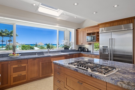 Prepare meals on the spacious kitchen area featuring top tier appliances and panoramic ocean views.