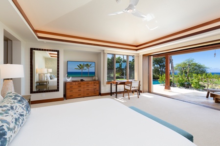 Primary bedroom suite with a king bed, smart TV, walk-in closet, distinct lanai, & en suite bath