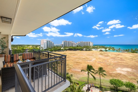 Expansive ocean views and tropical coastline from private balcony with comfortable seating area.